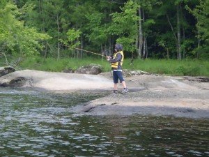 Christian tries his luck from a large rock